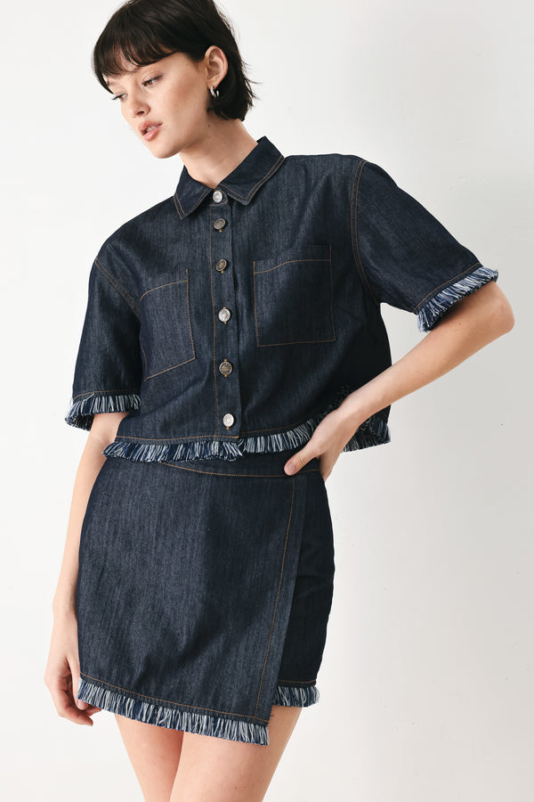 Woman wearing a dark denim crop jacket featuring short sleeve with fray edge and button down closure | FREEMARKET
