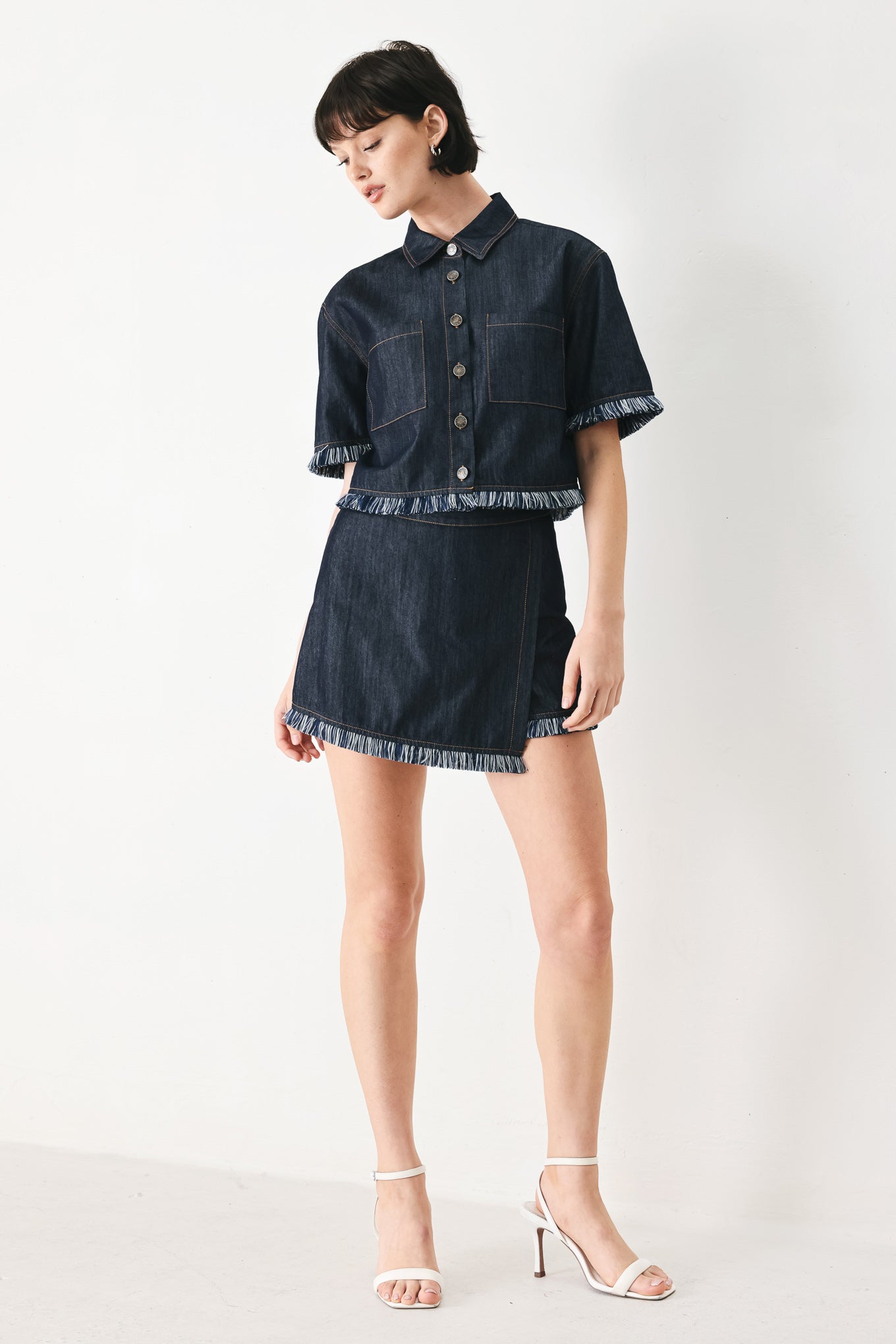 Woman wearing a dark denim crop jacket featuring short sleeve with fray edge and button down closure | FREEMARKET
