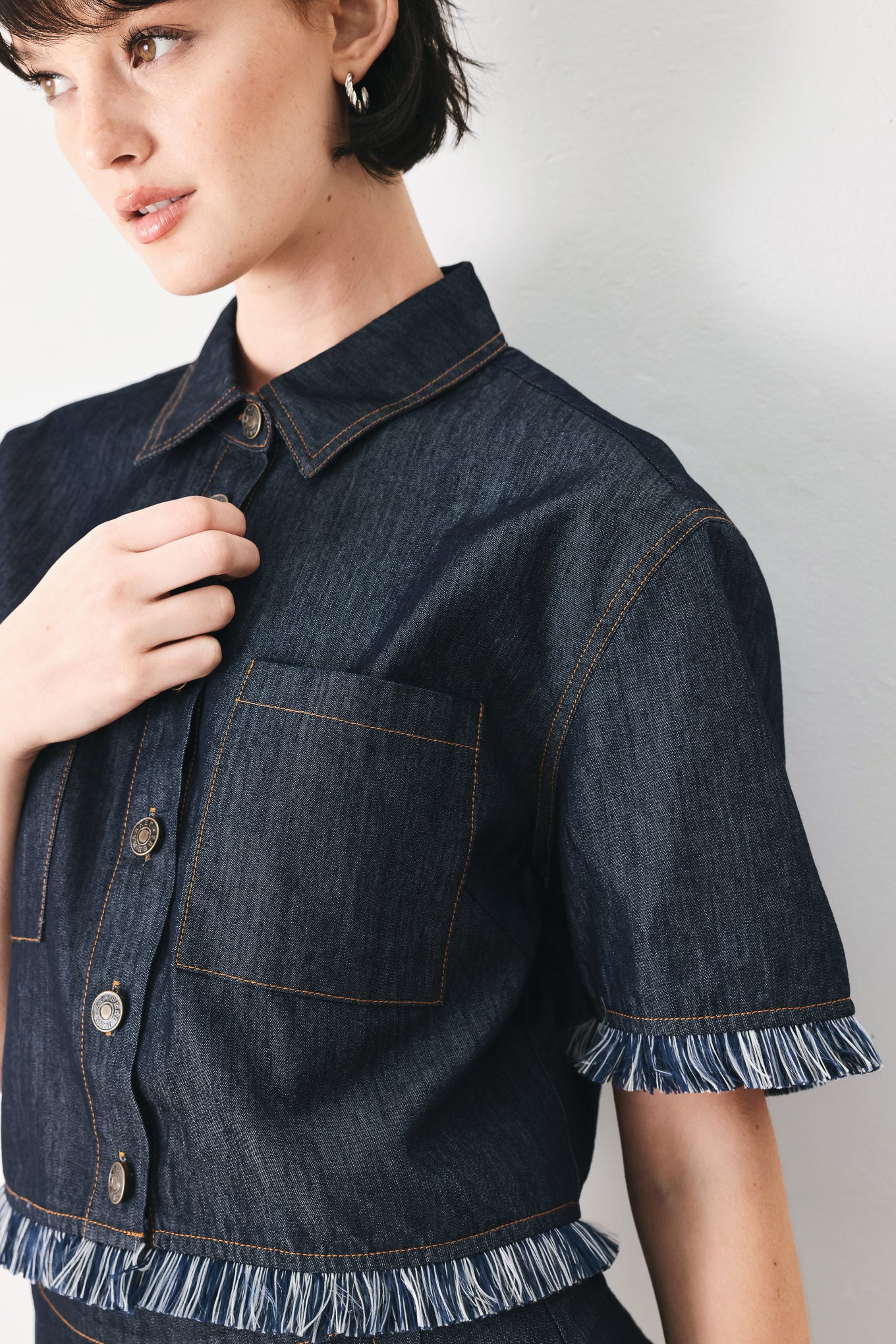 Woman wearing a dark denim crop jacket featuring short sleeve with fray edge and button down closure | FREEMARKET
