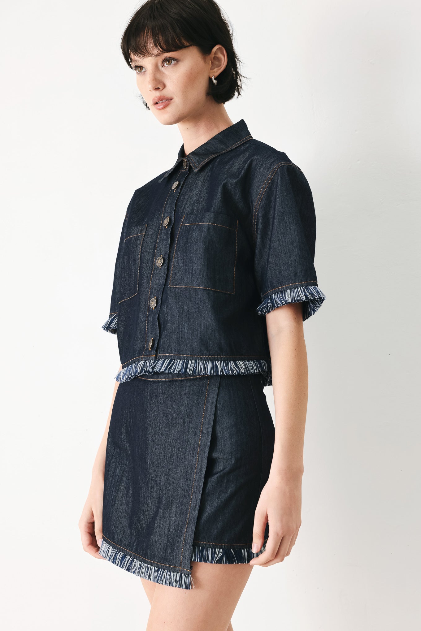Woman wearing a dark denim crop jacket featuring short sleeve with fray edge and button down closure | FREEMARKET