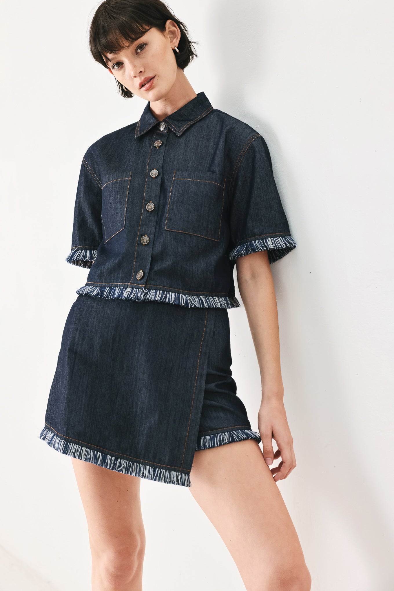 Woman wearing a dark denim crop jacket featuring short sleeve with fray edge and button down closure | FREEMARKET