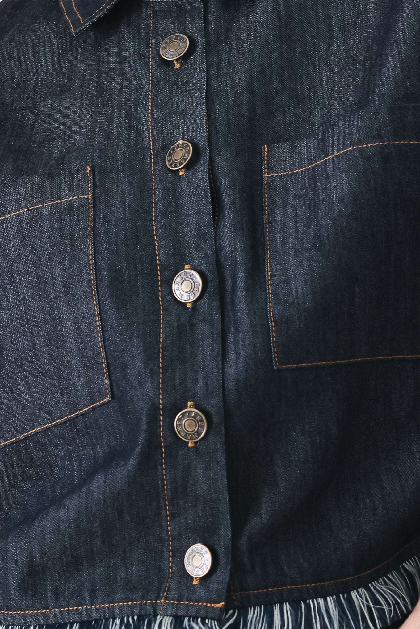 Close up of a dark denim crop jacket featuring short sleeve with fray edge and button down closure | FREEMARKET