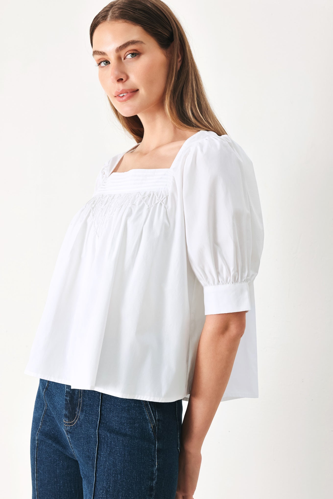 Woman wearing a white blouse featuring square neckline, elbow sleeve with cuff and back button closure | Flying Tomato
