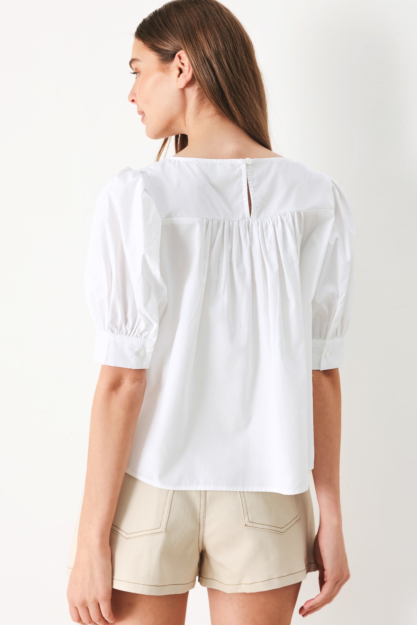 Woman wearing a white blouse featuring square neckline, elbow sleeve with cuff and back button closure | Flying Tomato