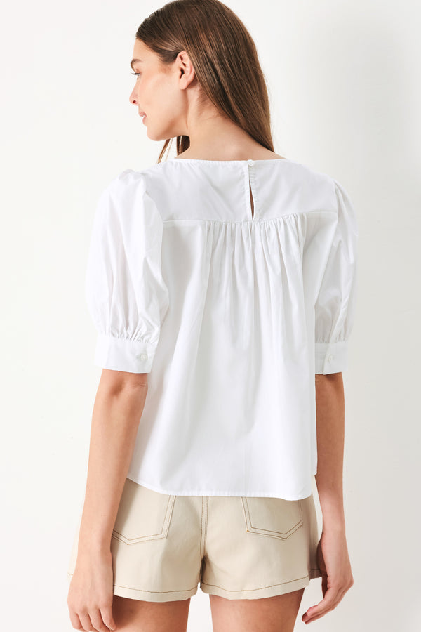 Woman wearing a white blouse featuring square neckline, elbow sleeve with cuff and back button closure | Flying Tomato