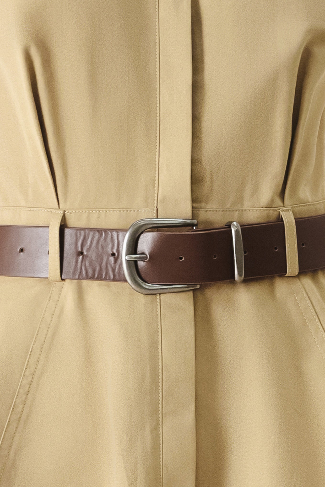 Close-up of a beige trench coat with a brown belt and silver buckle | FREEMARKET