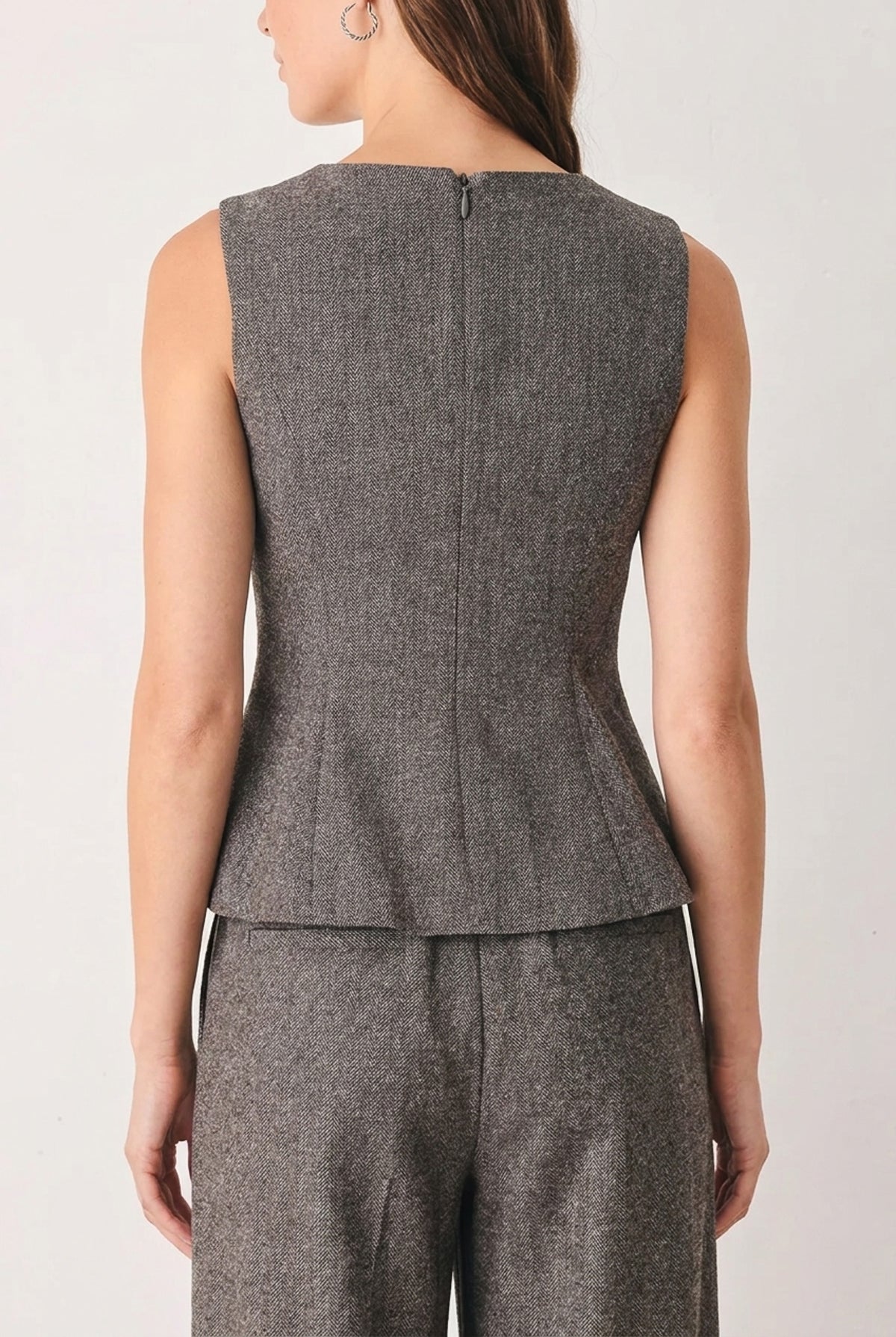 A solid woven top with V neckline, sleeveless, peplum and back zipper closure. Matching pant FP2191T
