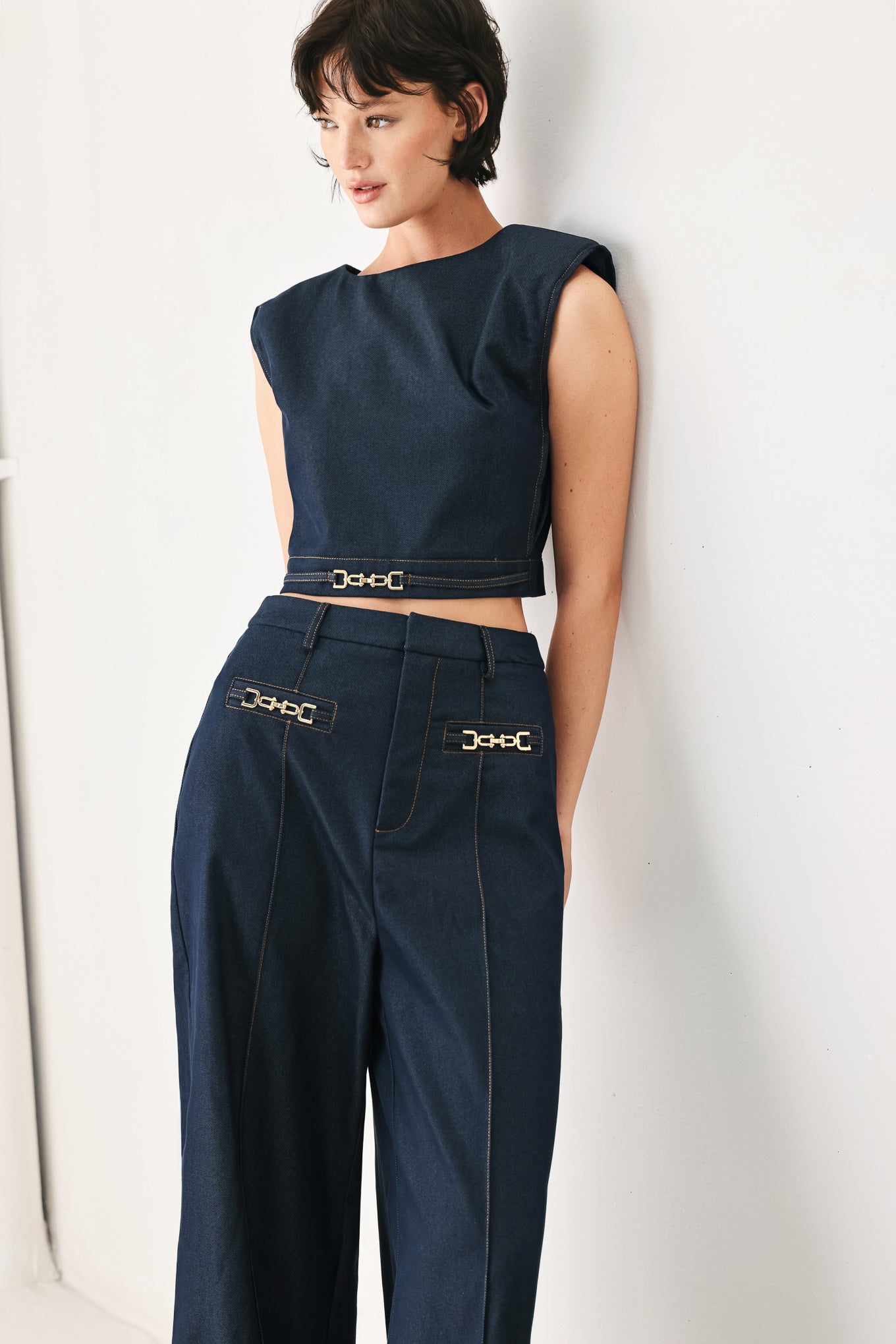 Woman wearing a navy blue sleeveless crop top with round neckline, hardware detail and back zipper closure | FREEMARKET