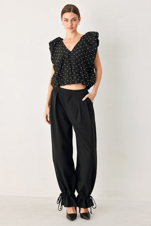 Woman wearing a black polka dot top featuring V neckline with bubble sleeve and waist | FREEMARKET