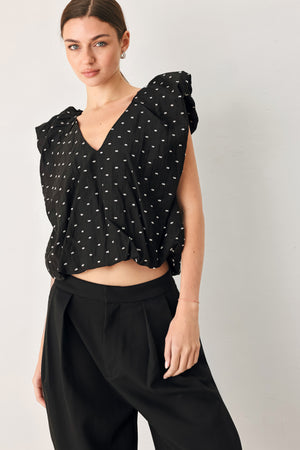 Woman wearing a black polka dot top featuring V neckline with bubble sleeve and waist | FREEMARKET