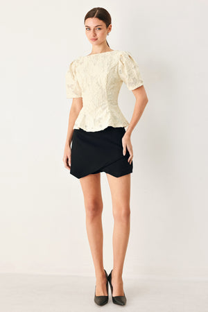 Woman wearing a white lace jacquard top featuring round neckline, short sleeve, peplum and V back with zipper closure | FREEMARKET
