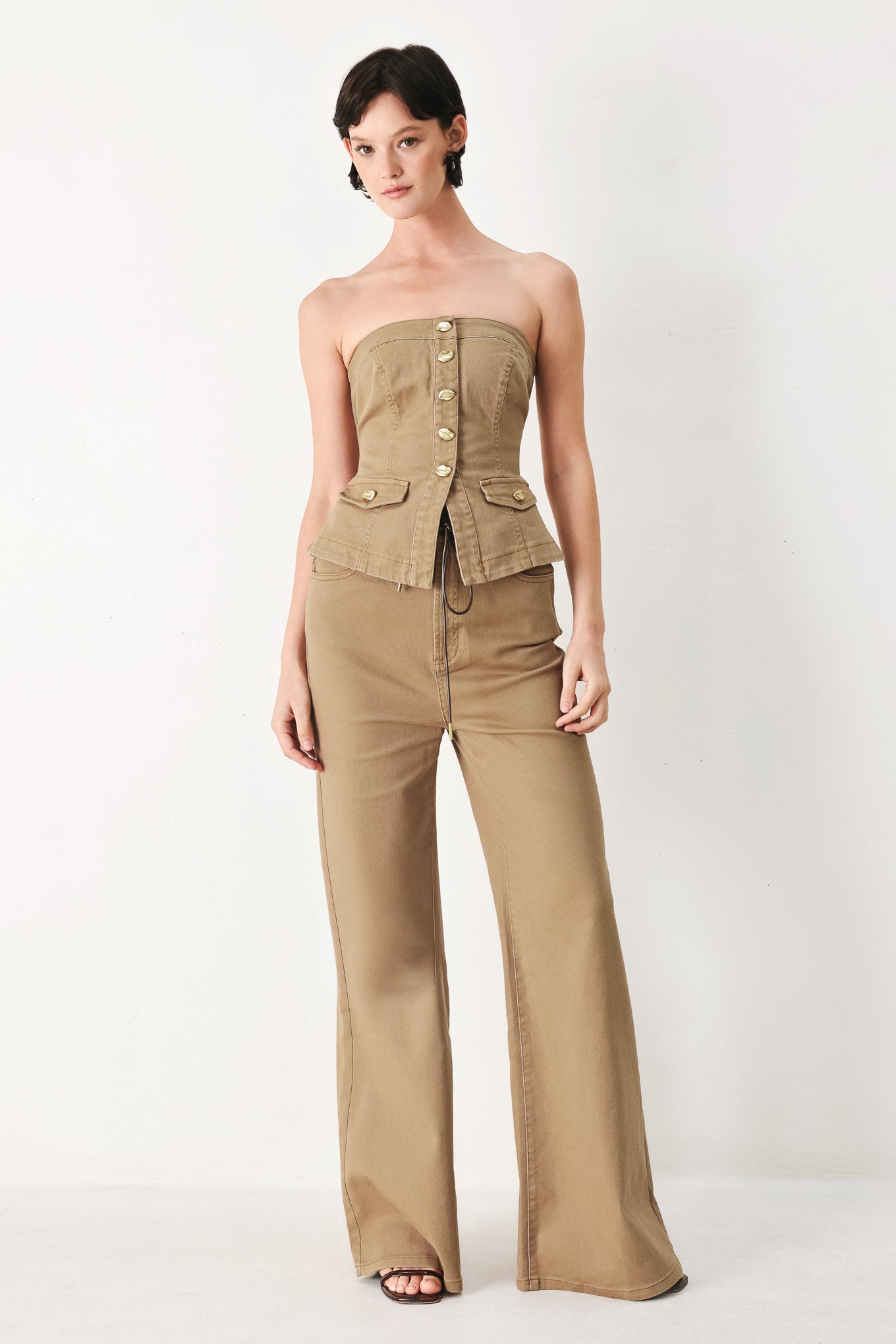 Woman wearing a khaki strapless tube top with front button detail and back zipper closure | FREEMARKET