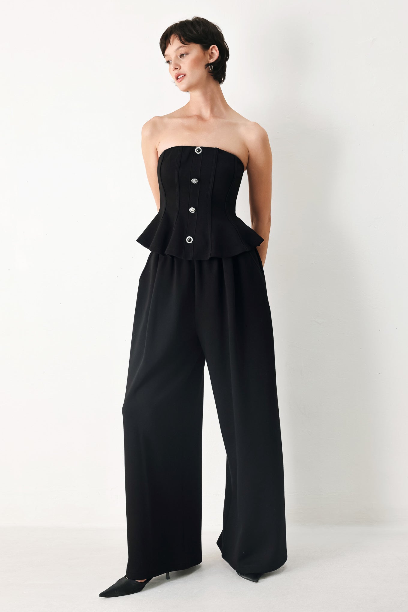 Woman wearing a black strapless tube top with buttons down the front | FREEMARKET