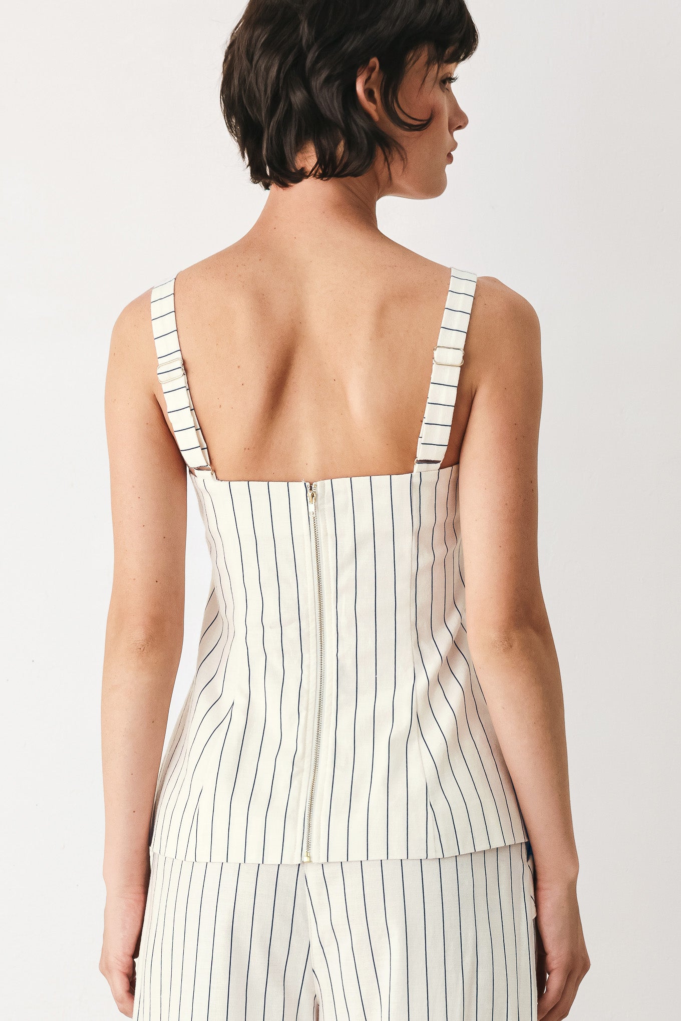 Woman wearing a top with navy pinstripes and gold buttons | FREEMARKET