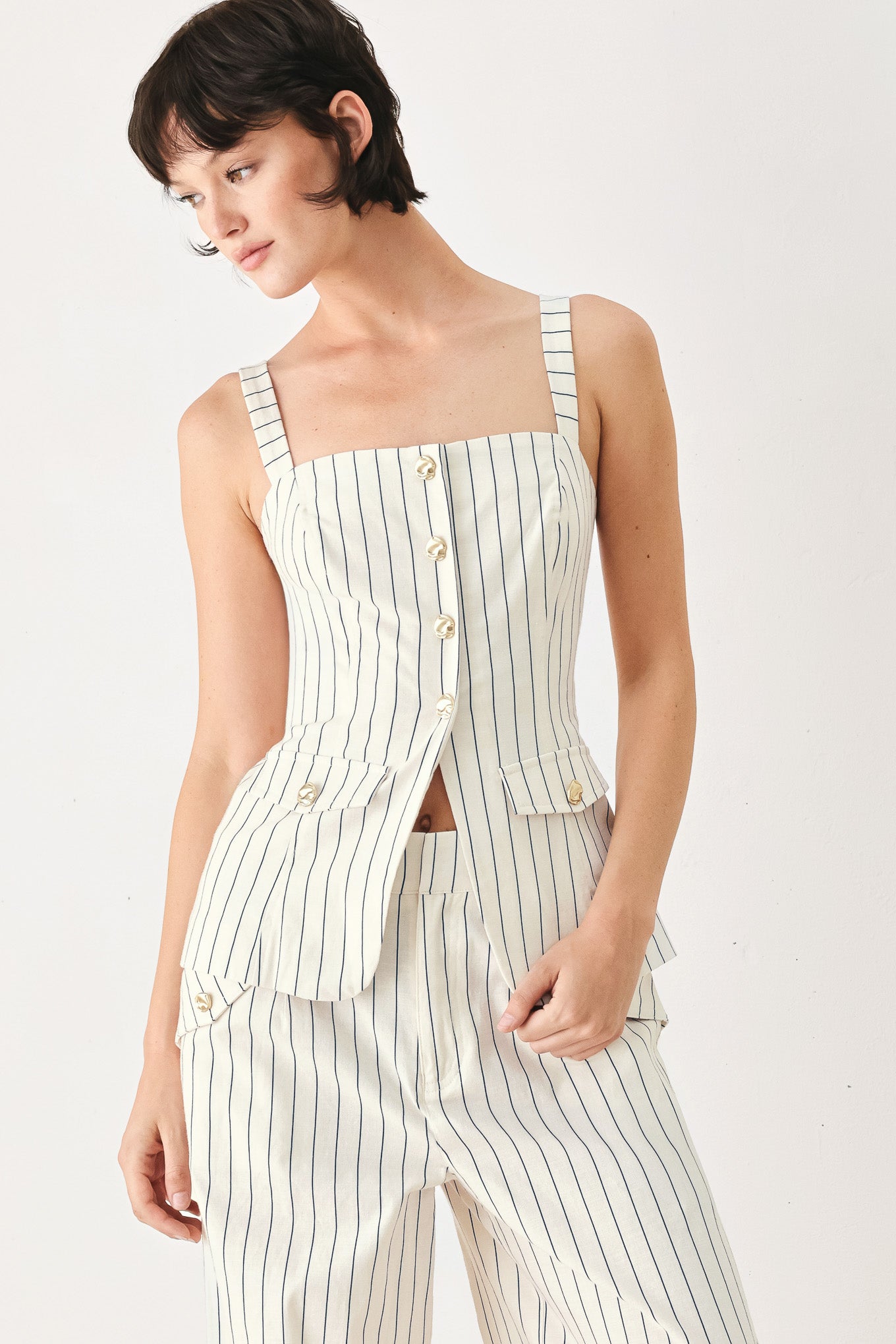 Woman wearing a top with navy pinstripes and gold buttons | FREEMARKET