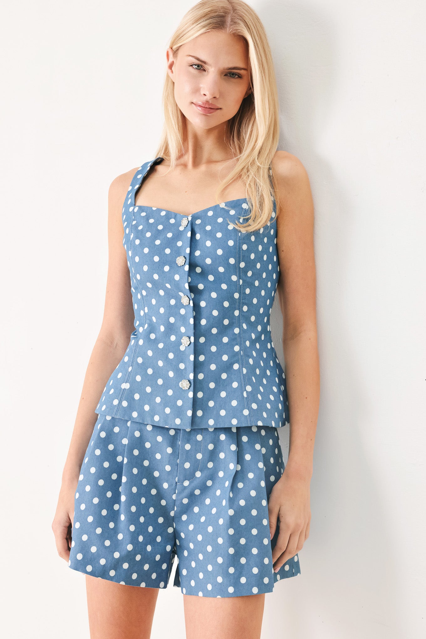 Woman wearing a blue polka dot top featuring sweetheart neckline, sleeveless, front button detail, peplum and back zipper closure | FREEMARKET