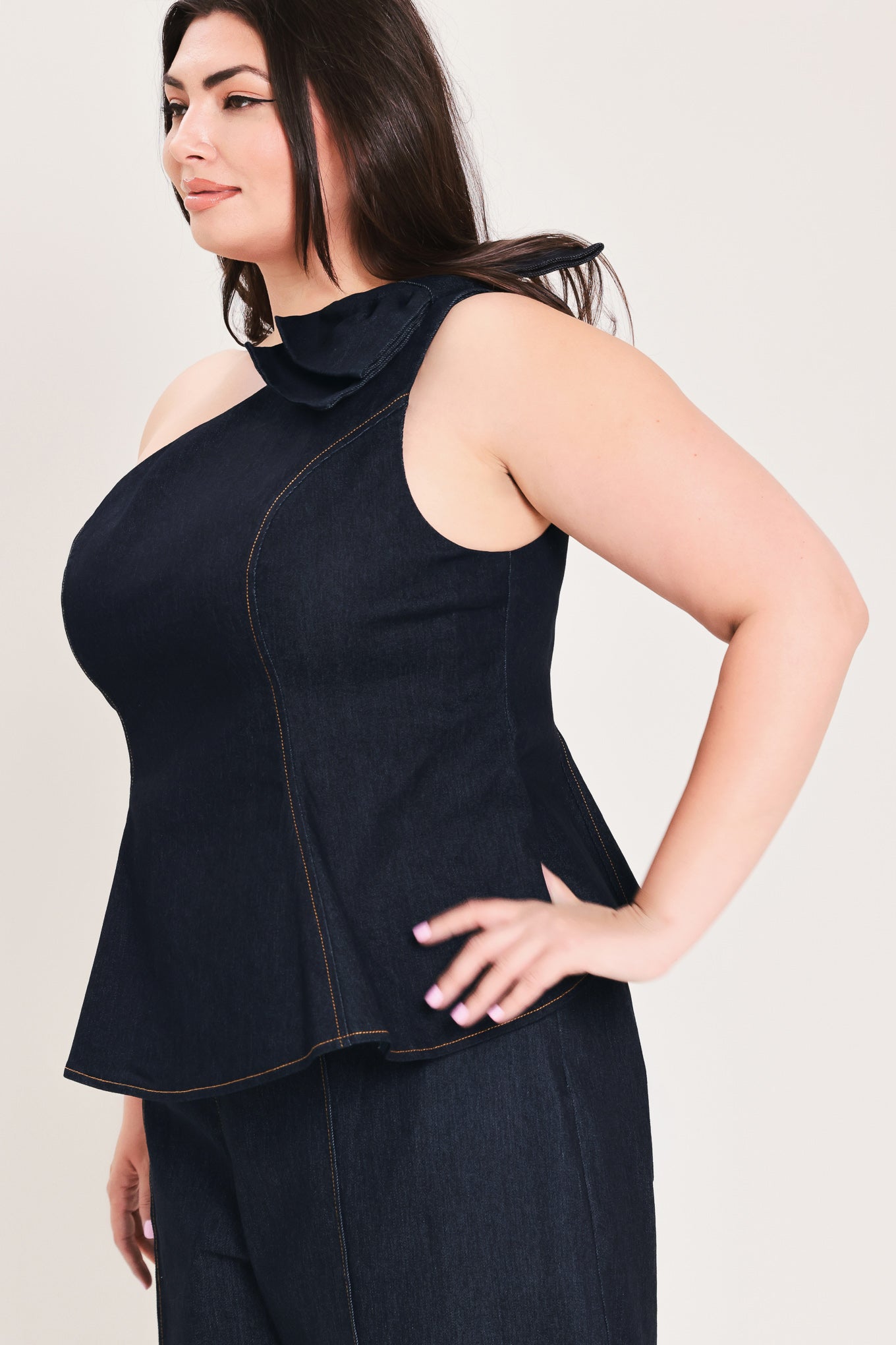 Woman wearing a dark blue denim one-shoulder peplum top with bow detail | FREEMARKET