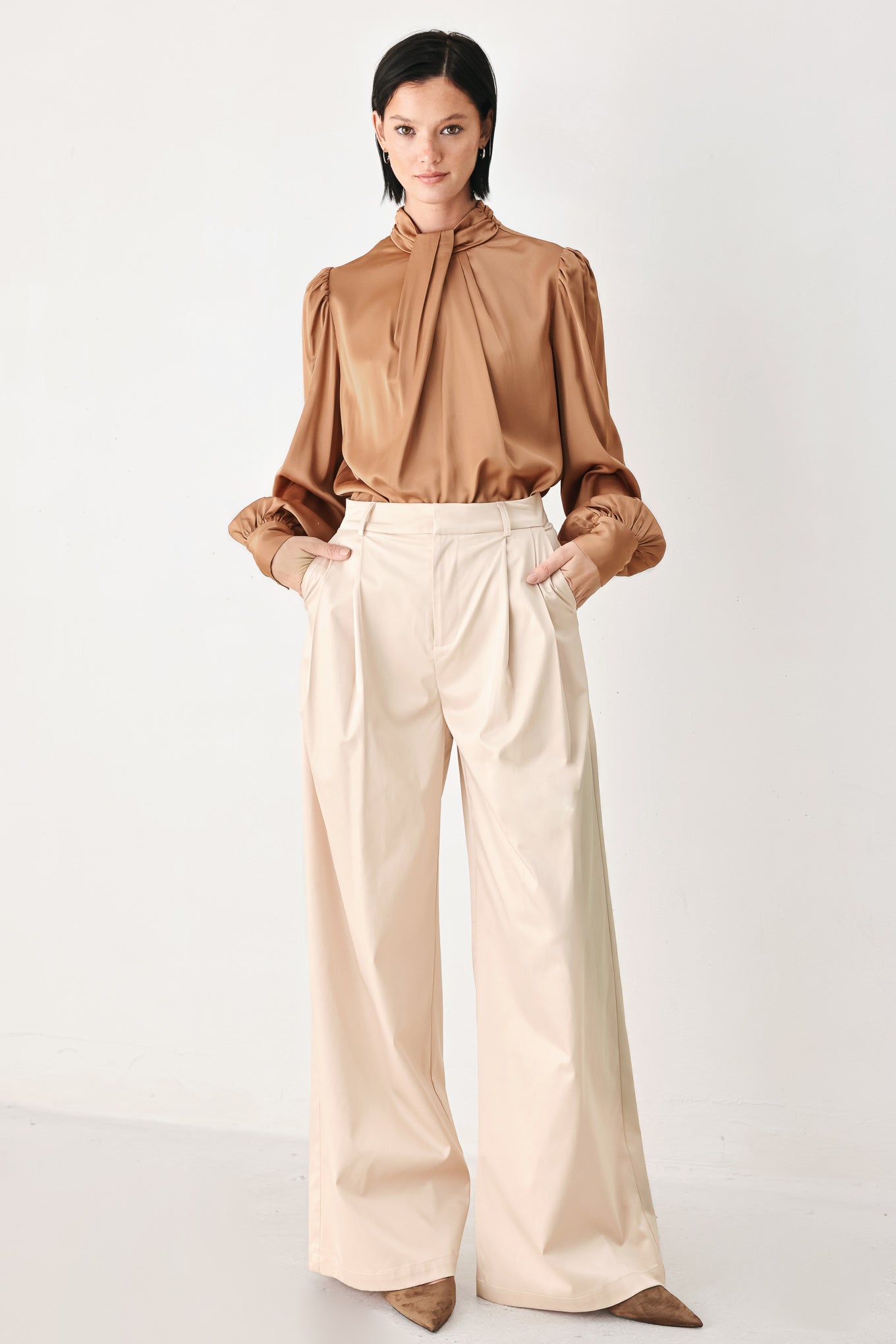 A woman wearing a bronze long-sleeve blouse with a gathered high neck and voluminous sleeves | FREEMARKET