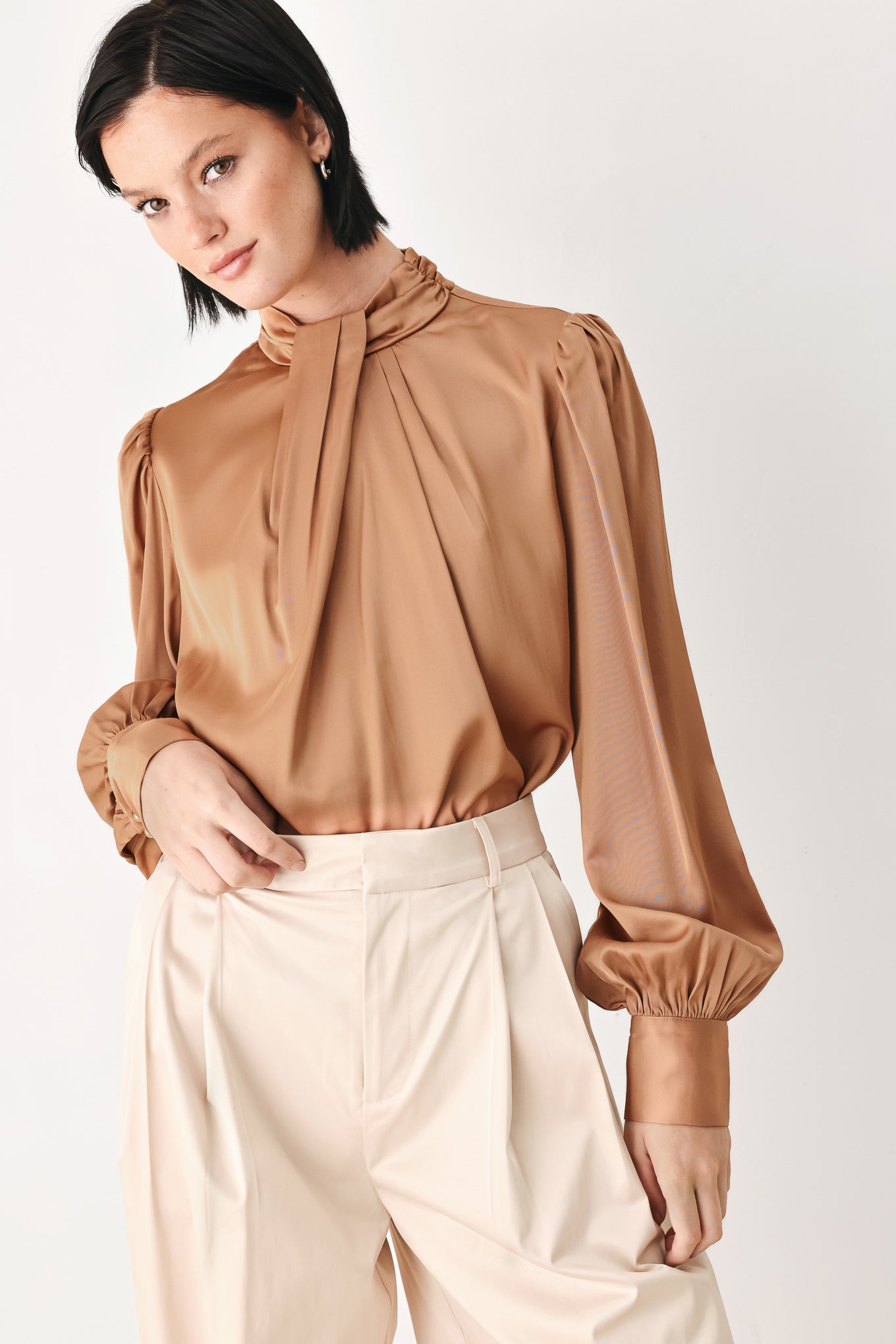 A woman wearing a bronze long-sleeve blouse with a gathered high neck and voluminous sleeves | FREEMARKET