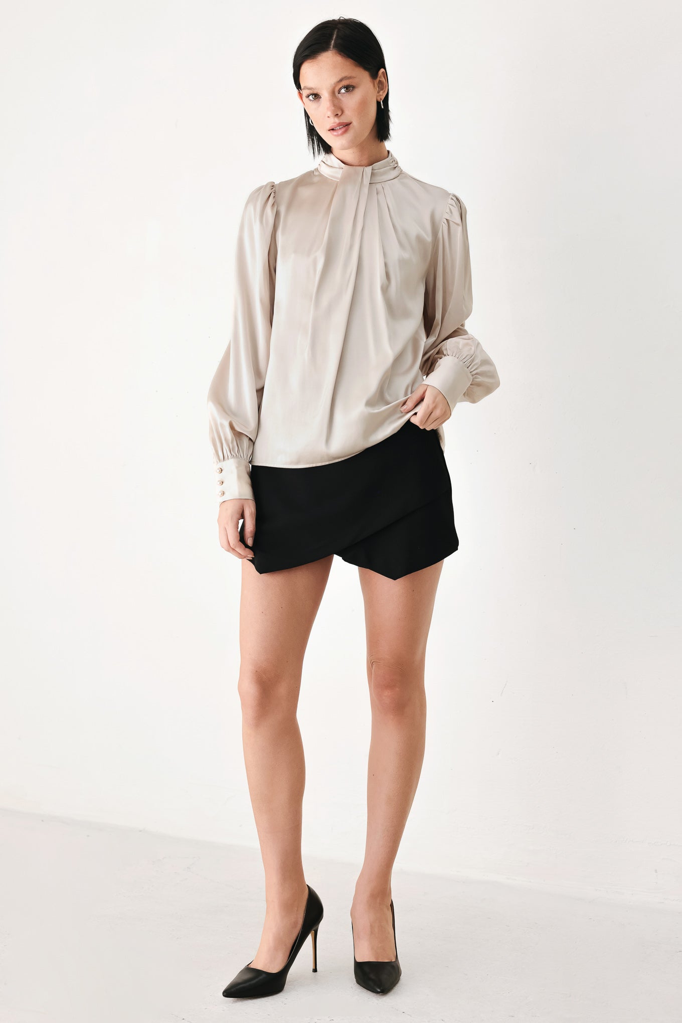A woman wearing a champagne ivory long-sleeve blouse with a gathered high neck and voluminous sleeves | FREEMARKET