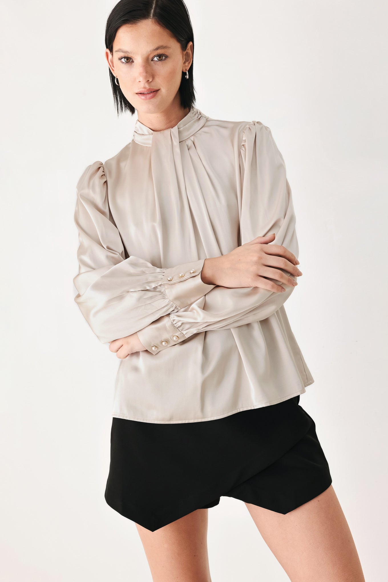 A woman wearing a champagne ivory long-sleeve blouse with a gathered high neck and voluminous sleeves | FREEMARKET