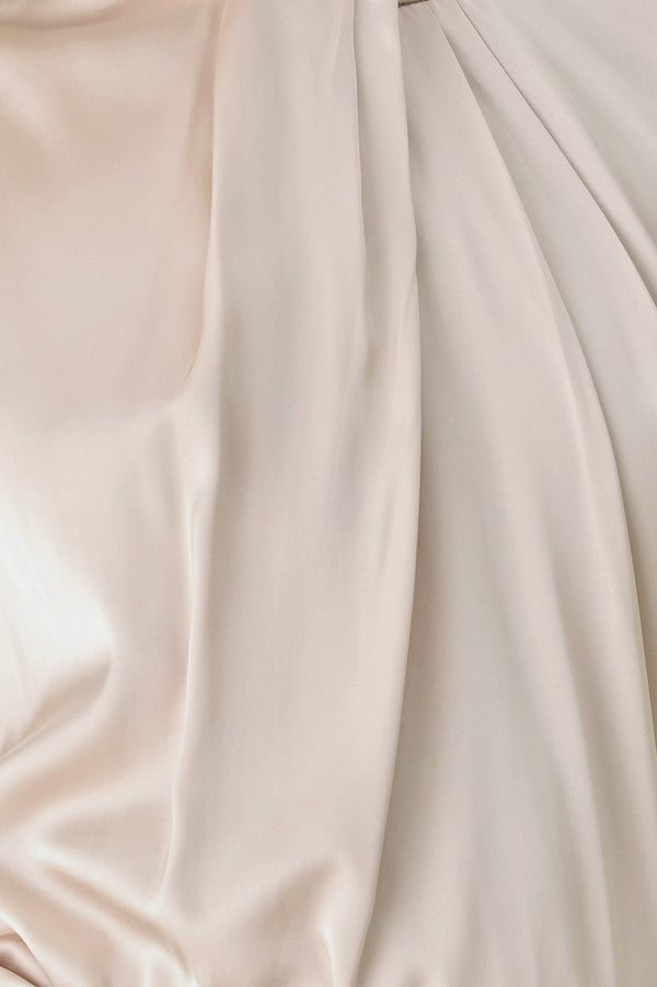 A woman wearing a champagne ivory long-sleeve blouse with a gathered high neck and voluminous sleeves | FREEMARKET