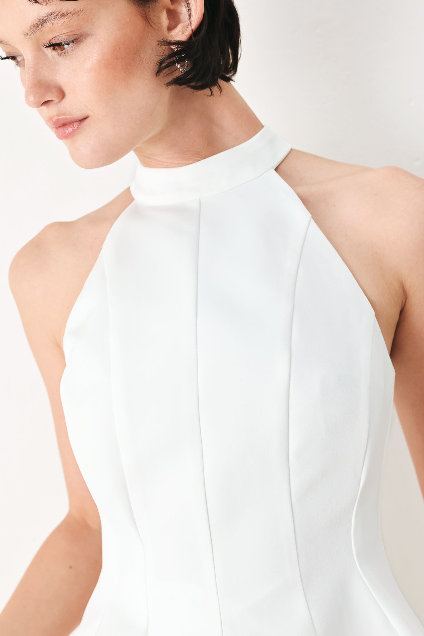 Woman wearing a white peplum top featuring halter neckline and back zipper closure | FREEMARKET