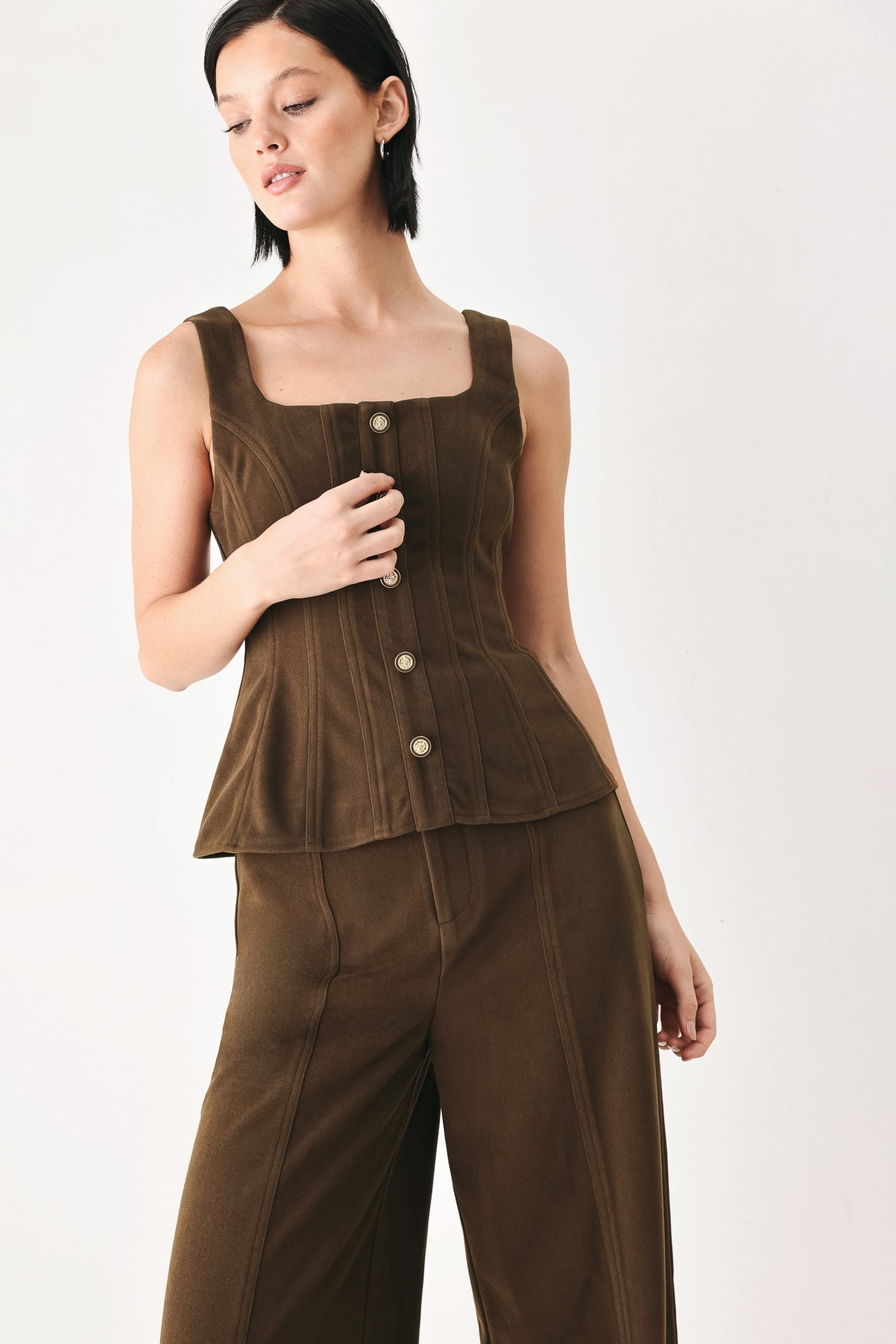 A woman wearing a brown sleeveless vest with a square neckline, front button closure, and vertical seam detailing | FREEMARKET