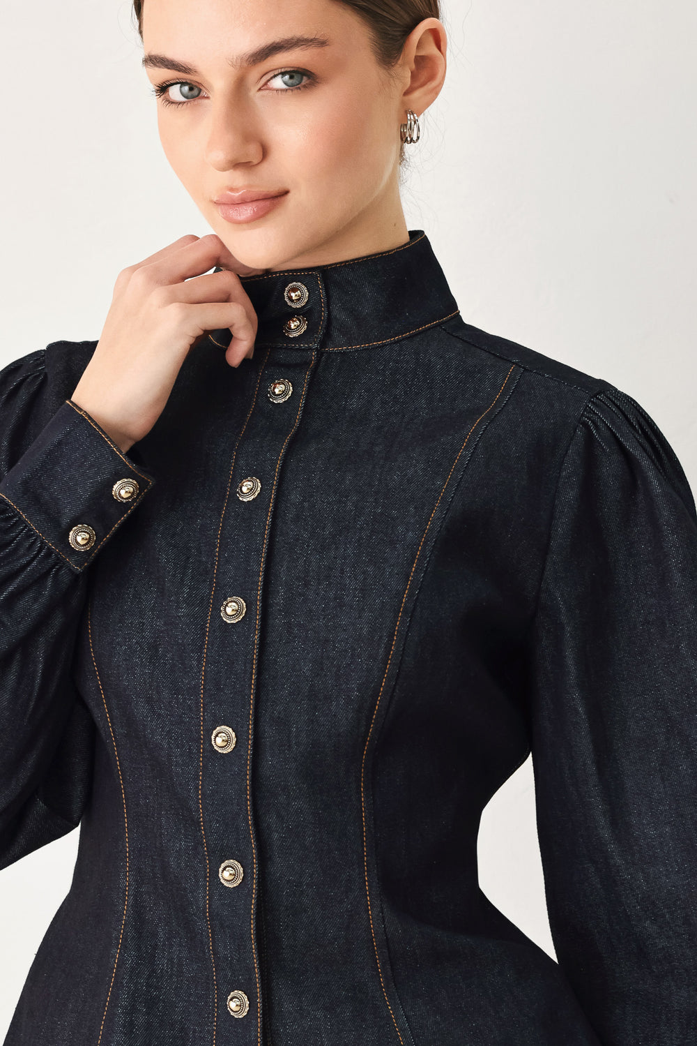 Woman wearing lightweight dark denim top with high neckline, long sleeve, front button down and peplum | FREEMARKET