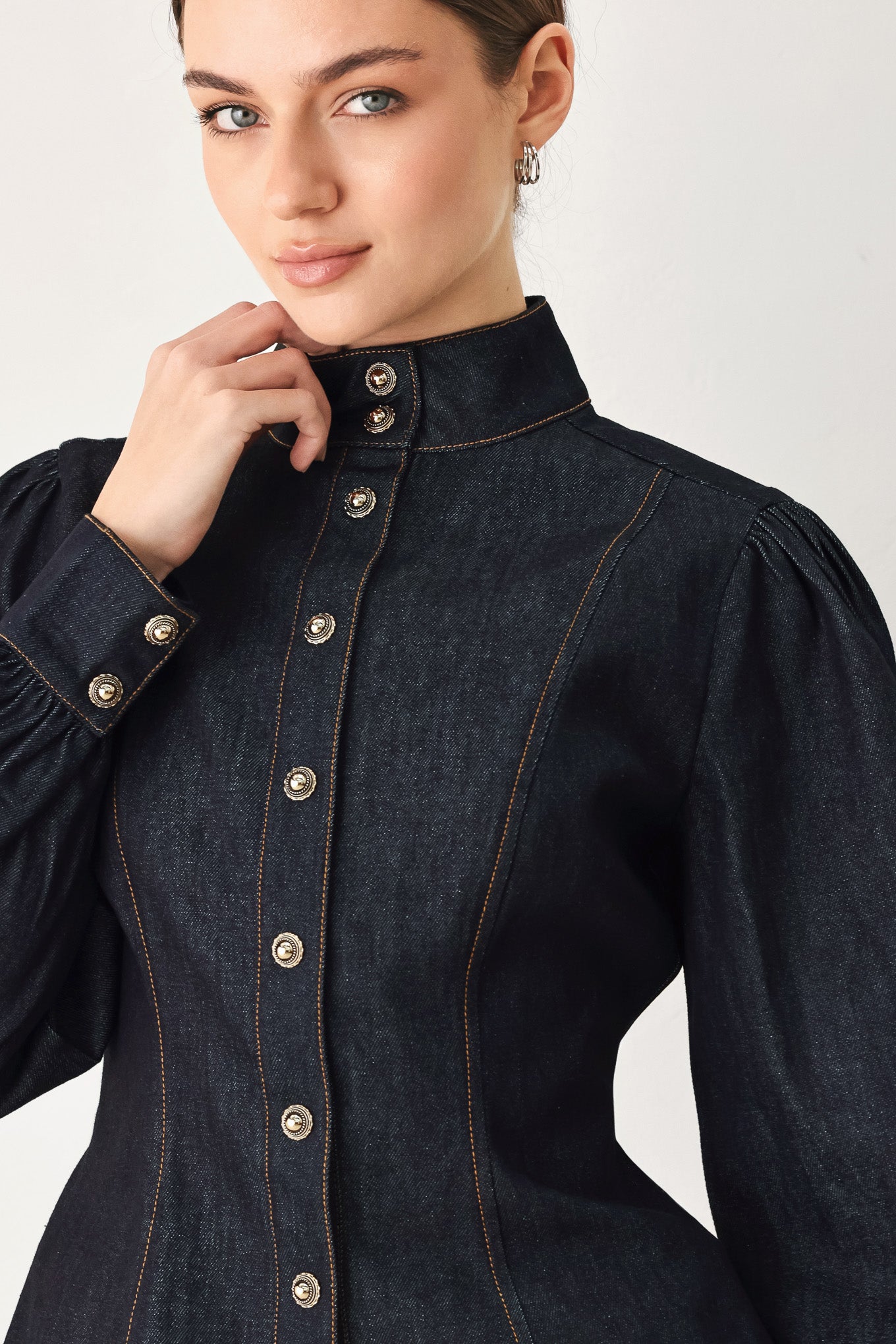 Woman wearing lightweight dark denim top with high neckline, long sleeve, front button down and peplum | FREEMARKET