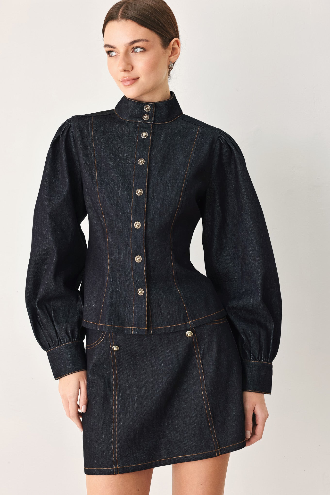 Woman wearing lightweight dark denim top with high neckline, long sleeve, front button down and peplum | FREEMARKET