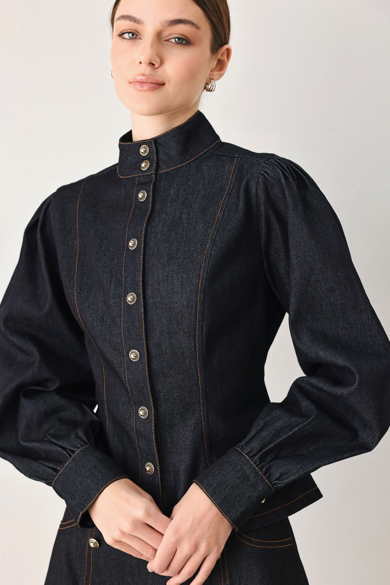 Woman wearing lightweight dark denim top with high neckline, long sleeve, front button down and peplum | FREEMARKET
