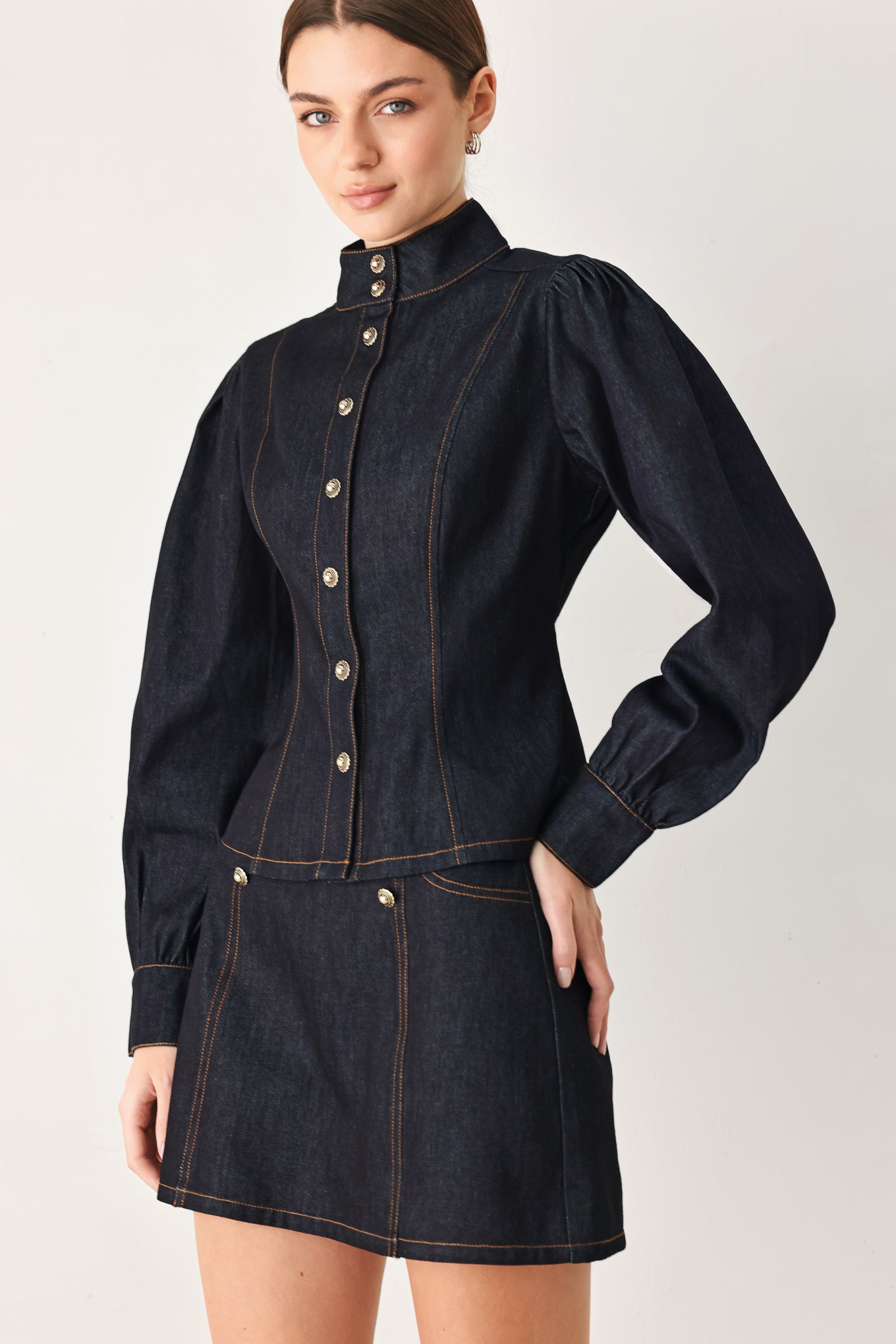 Woman wearing lightweight dark denim top with high neckline, long sleeve, front button down and peplum | FREEMARKET