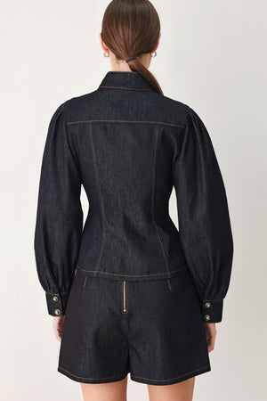 Woman wearing lightweight dark denim top with high neckline, long sleeve, front button down and peplum | FREEMARKET
