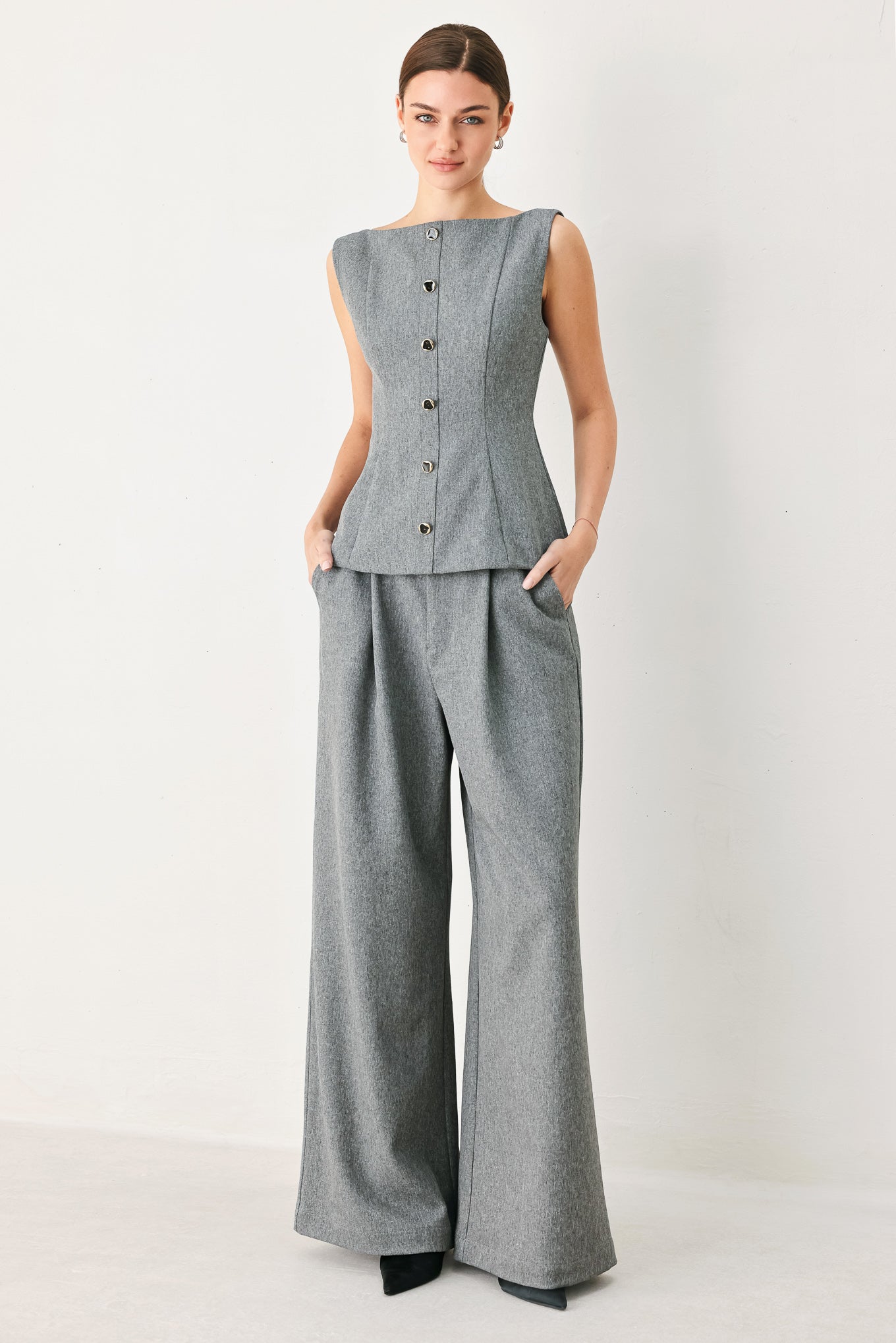 A woman wearing a gray sleeveless button-front top featuring wide neckline | FREEMARKET