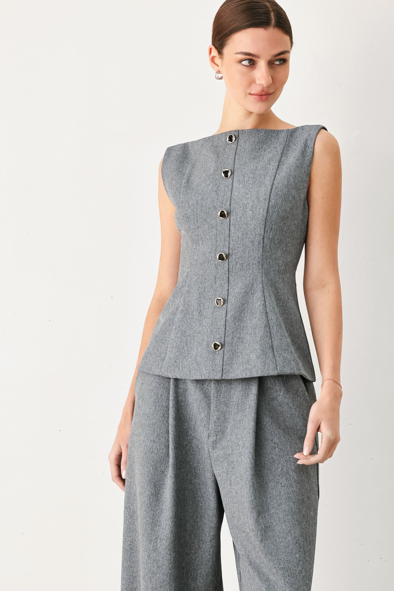 A woman wearing a gray sleeveless button-front top featuring wide neckline | FREEMARKET