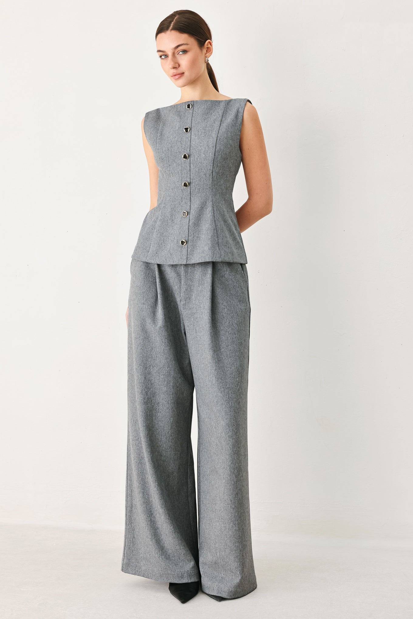 A woman wearing a gray sleeveless button-front top featuring wide neckline | FREEMARKET