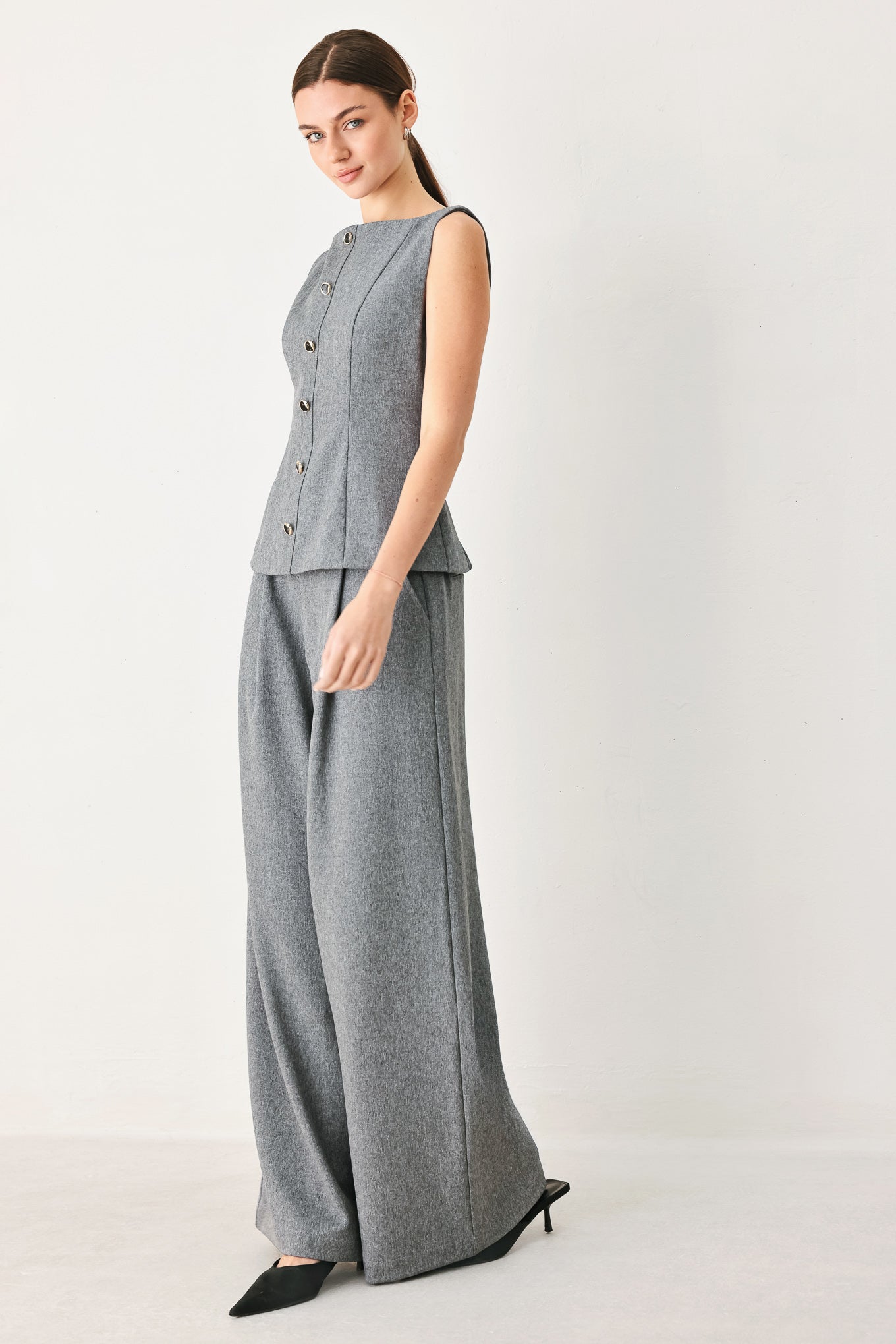 A woman wearing a gray sleeveless button-front top featuring wide neckline | FREEMARKET