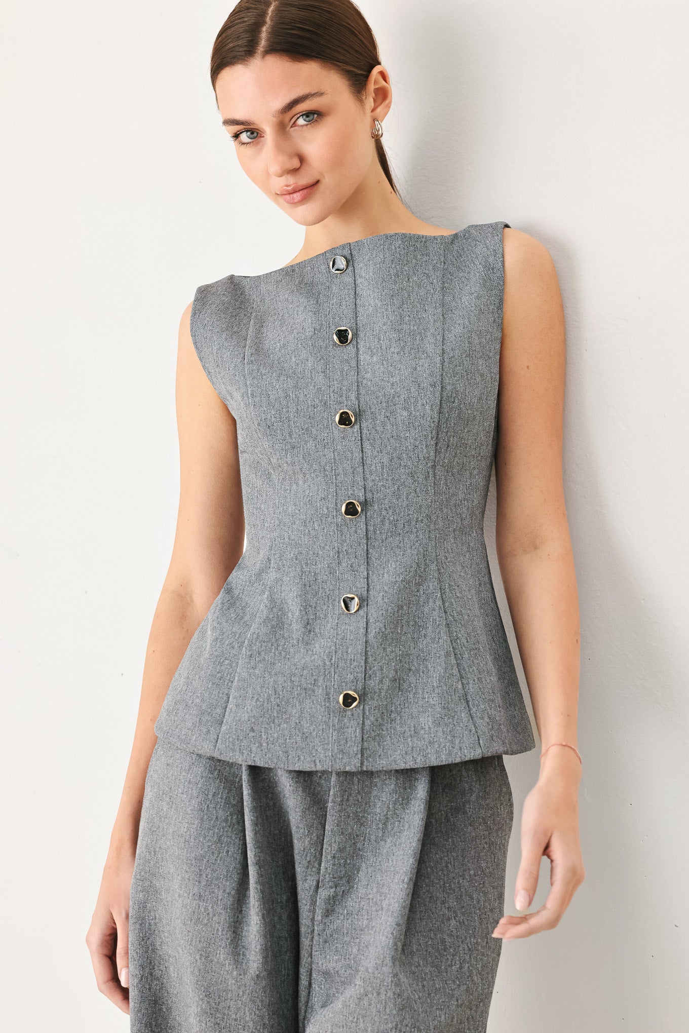 A woman wearing a gray sleeveless button-front top featuring wide neckline | FREEMARKET