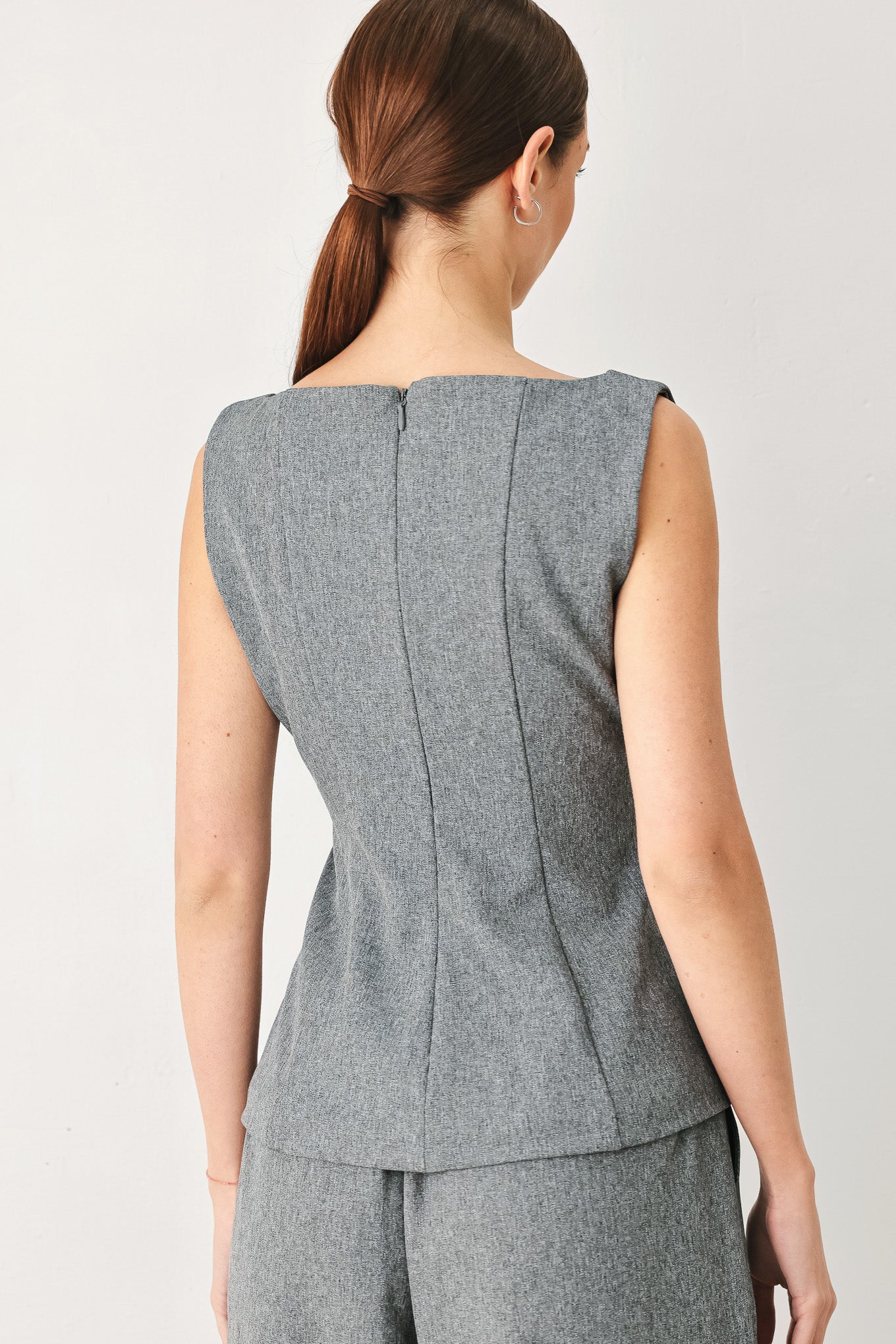 A woman wearing a gray sleeveless button-front top featuring wide neckline | FREEMARKET