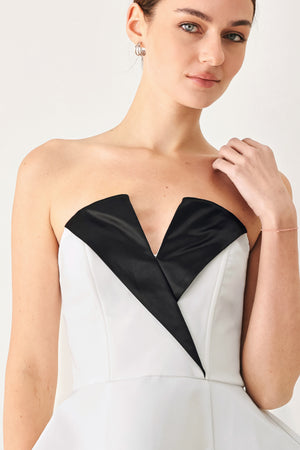 Woman wearing a black and white strapless top with a peplum effect | FREEMARKET
