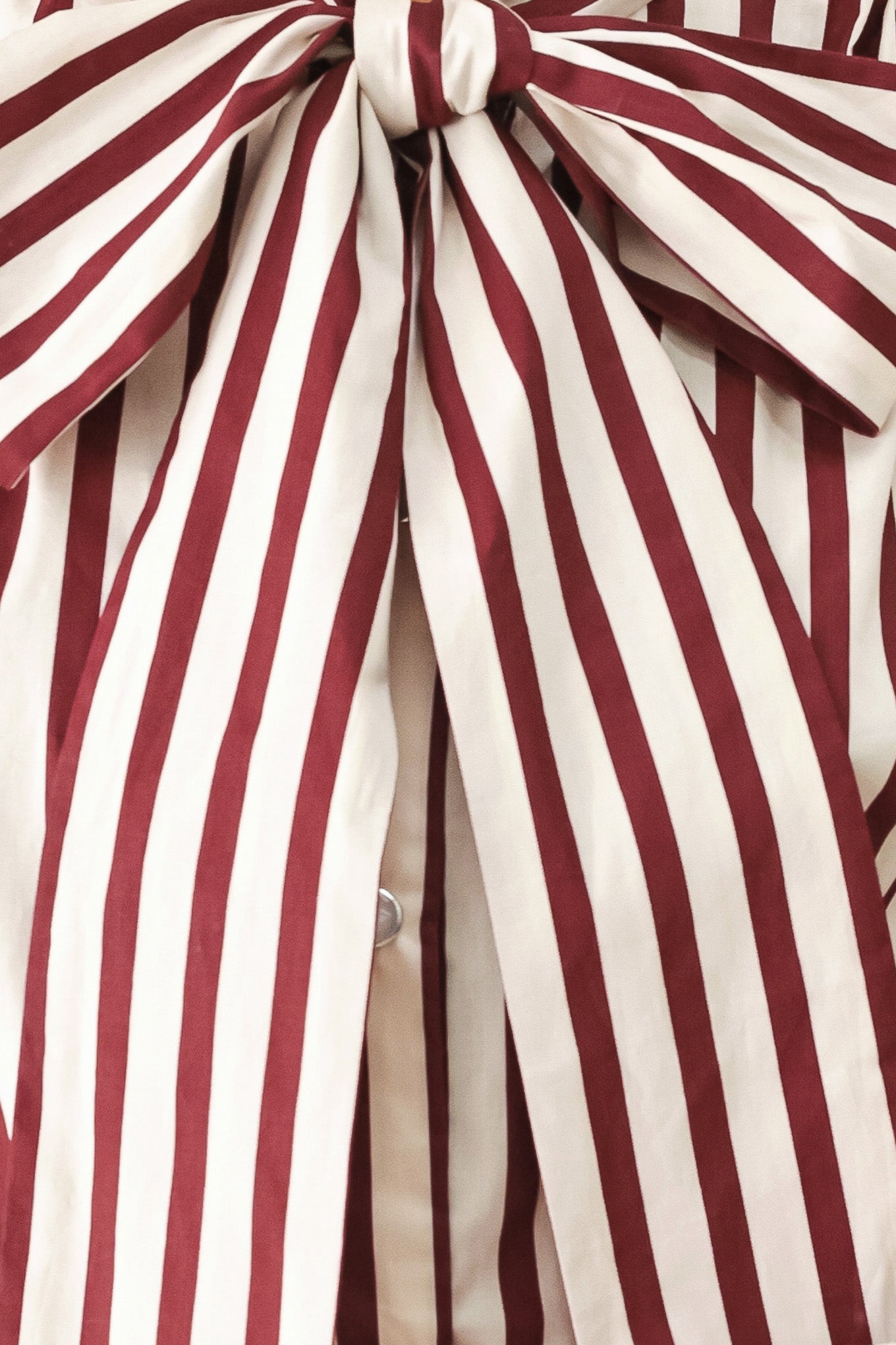 A woman wearing a burgundy and beige vertically striped long-sleeve blouse with a large bow at the collar | FREEMARKET