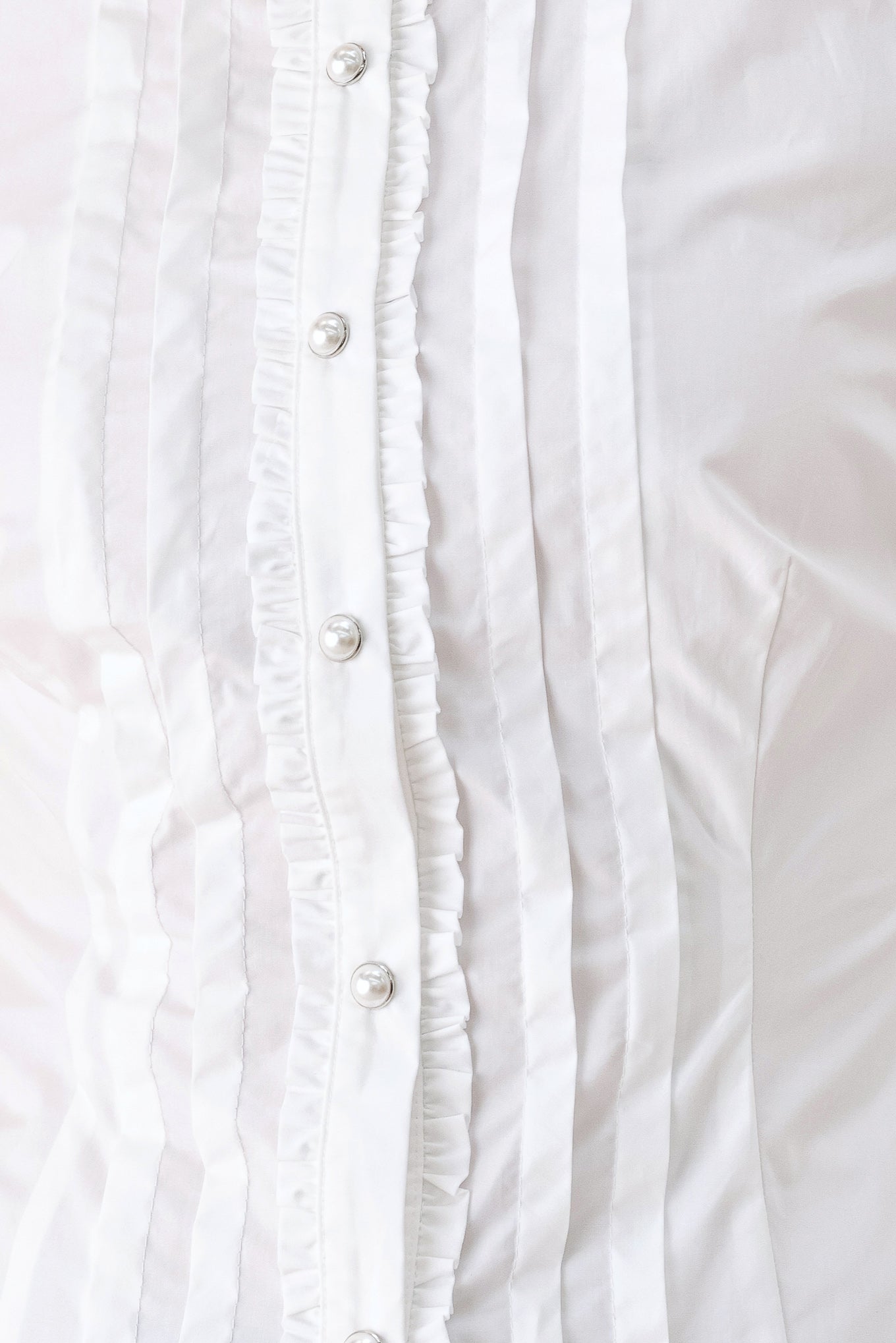 A woman wearing a white long-sleeve blouse with a high collar, decorative front pleats, and puffed shoulders | FREEMARKET
