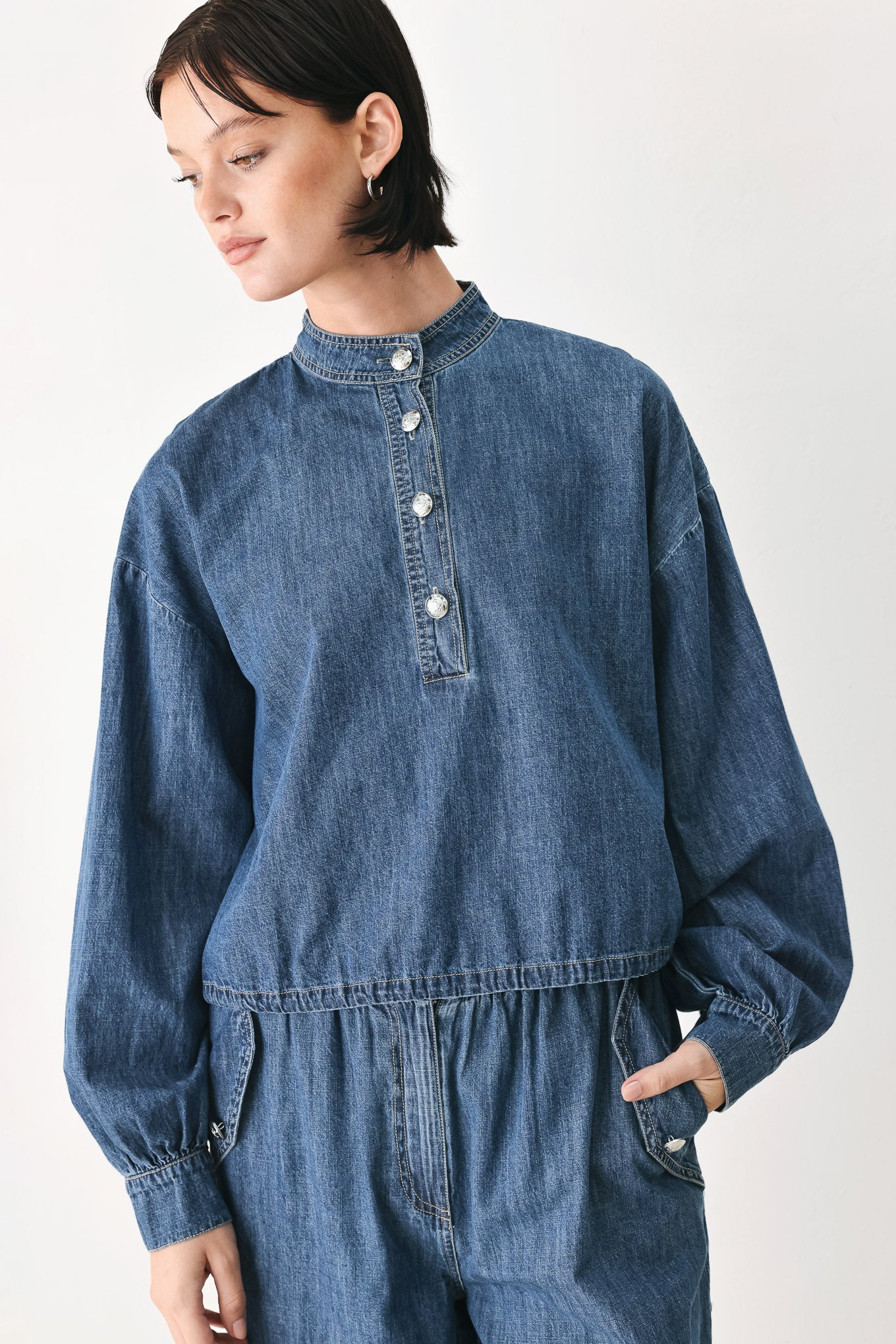 A model wearing a blue denim long-sleeve top with a buttoned mandarin collar | FREEMARKET
