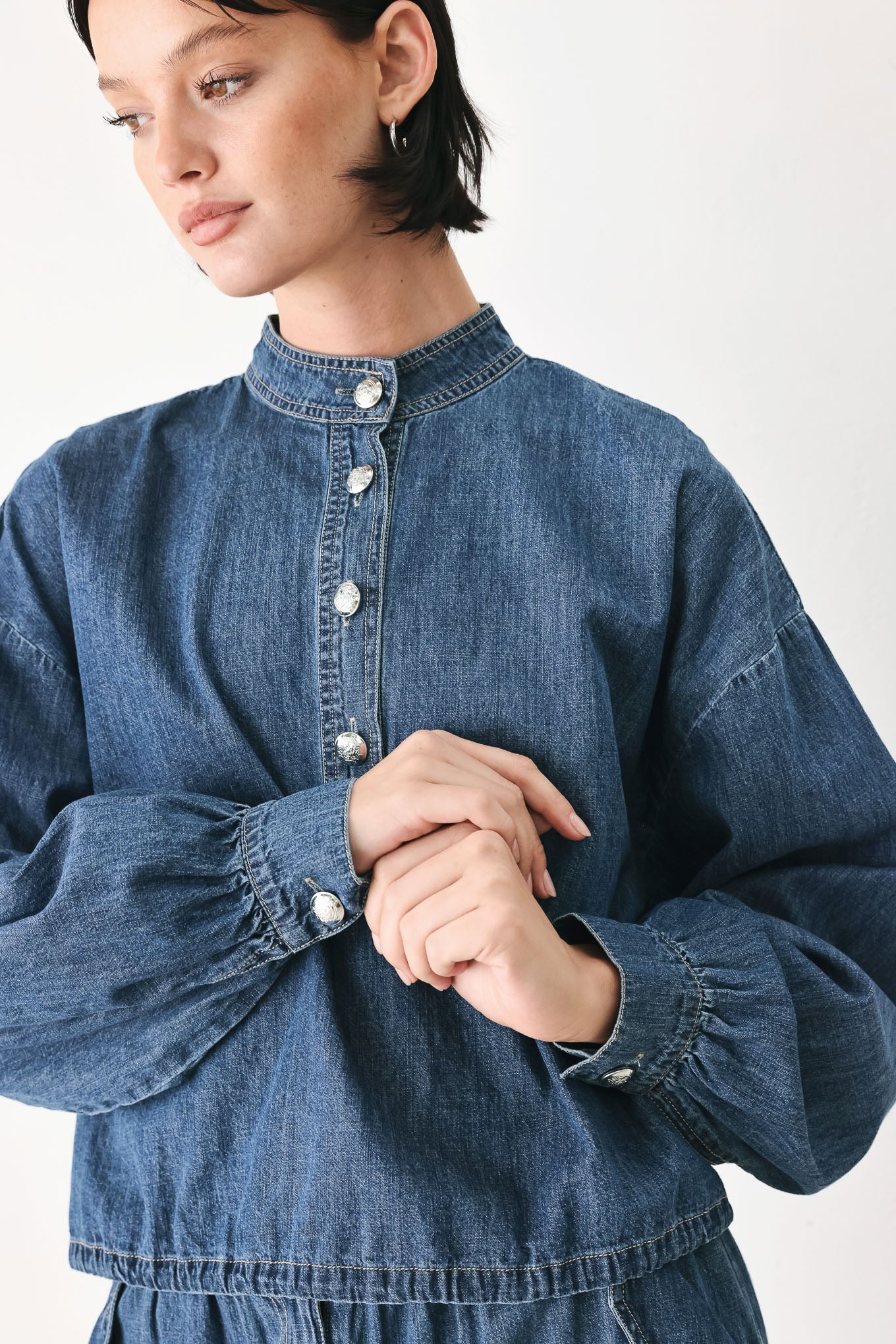 A model wearing a blue denim long-sleeve top with a buttoned mandarin collar | FREEMARKET