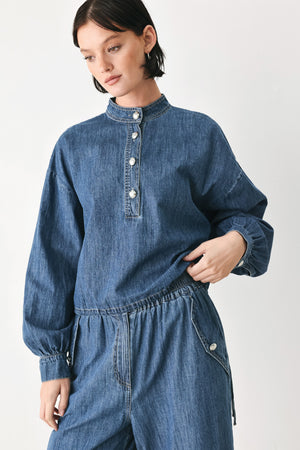 A model wearing a blue denim long-sleeve top with a buttoned mandarin collar | FREEMARKET