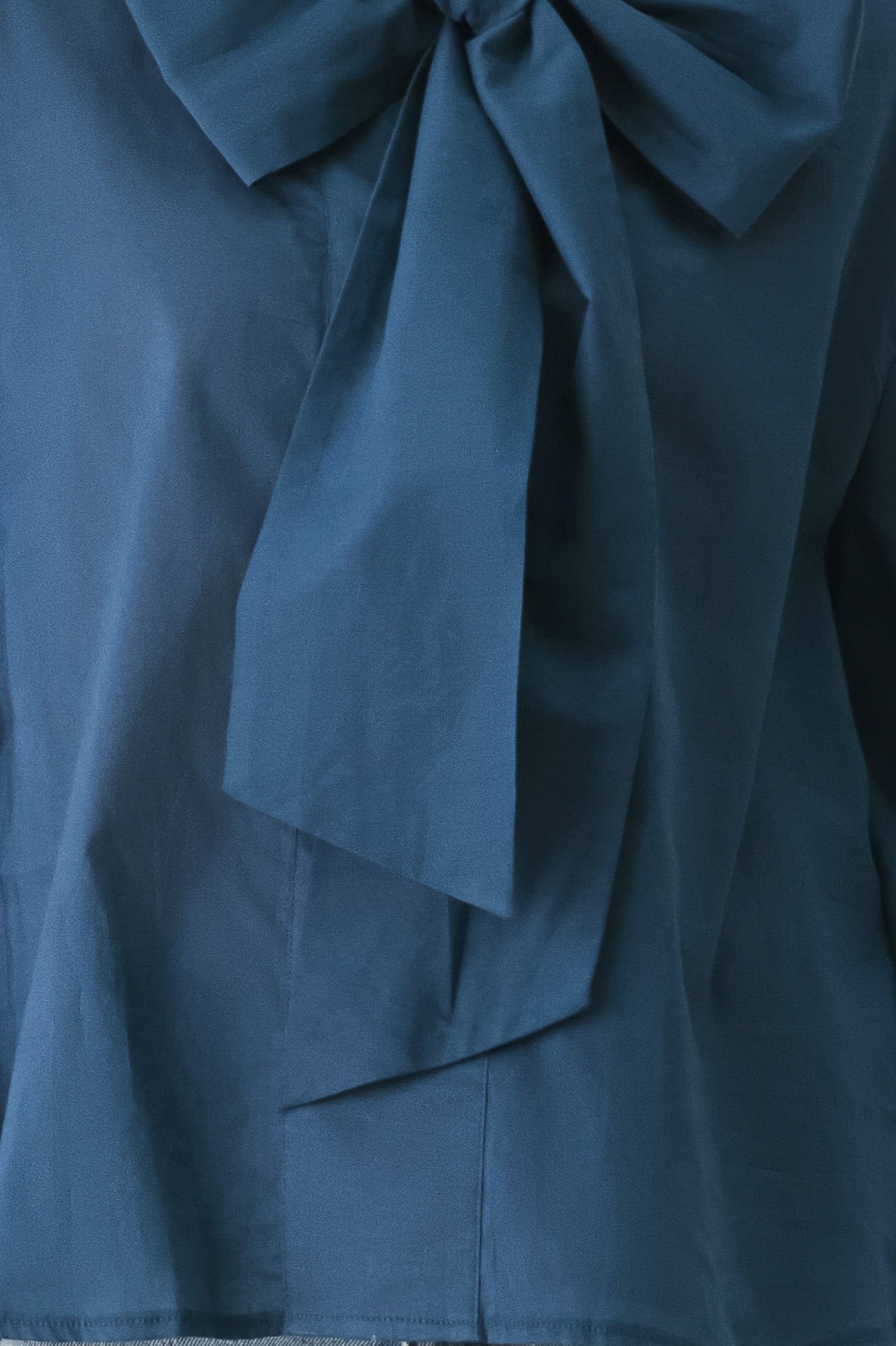 A woman wearing a dark navy blue long-sleeve blouse with a large bow at the collar | FREEMARKET