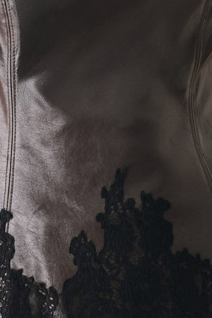 A model wearing a dark brown faux-leather corset top with a sweetheart neckline and black lace trim at the waist | FREEMARKET