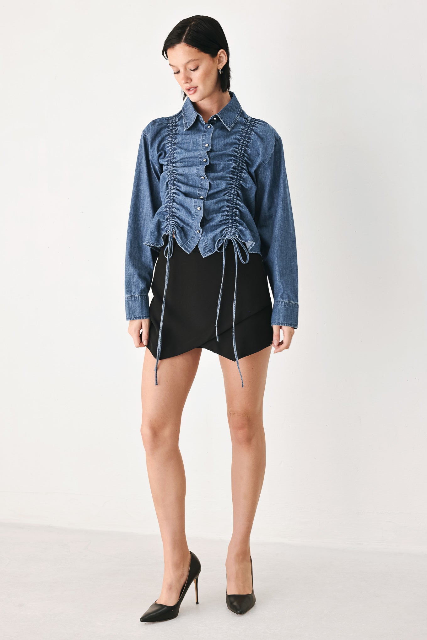 A model wearing a blue denim long-sleeve button-up shirt with ruched detailing | FREEMARKET