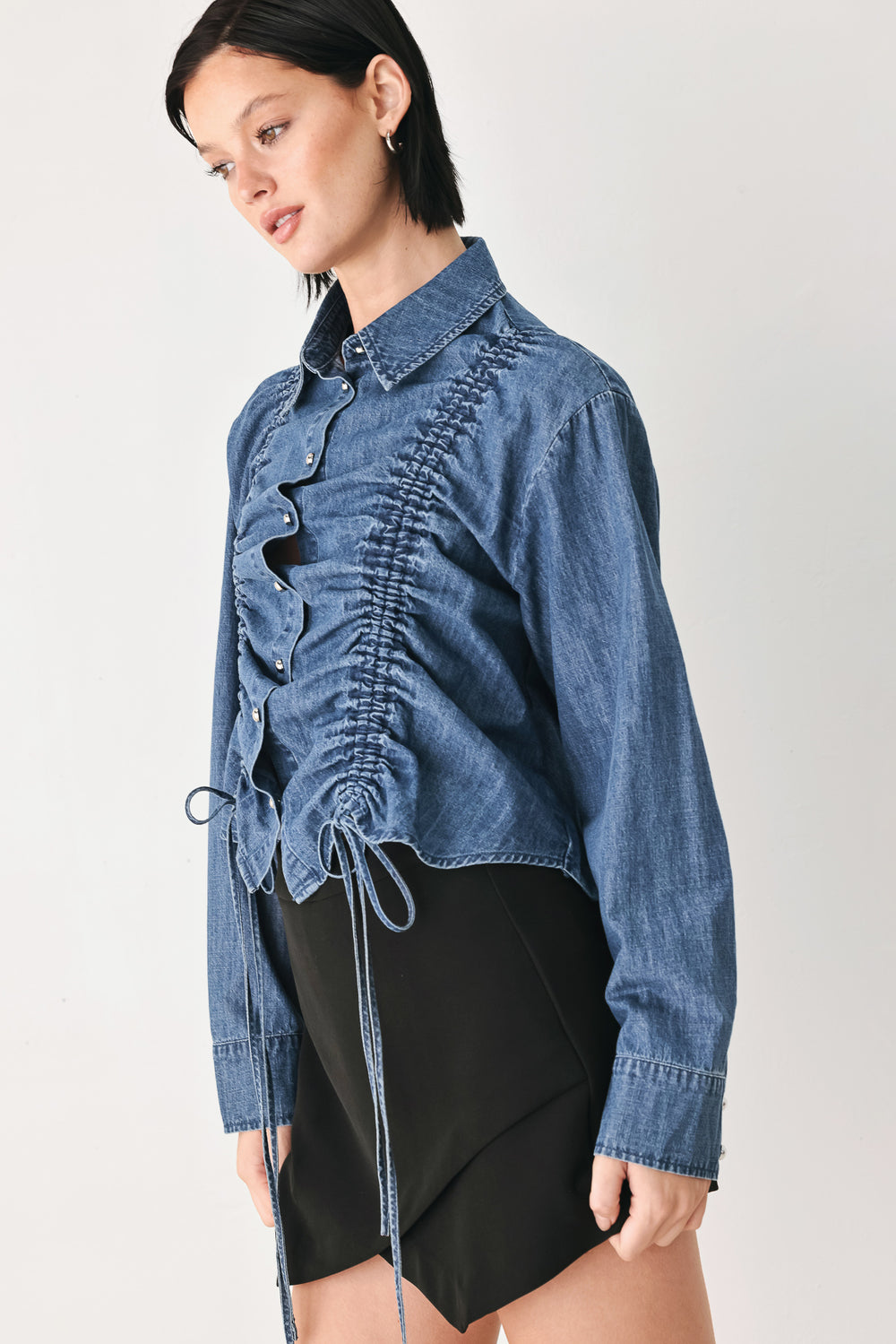 A model wearing a blue denim long-sleeve button-up shirt with ruched detailing | FREEMARKET
